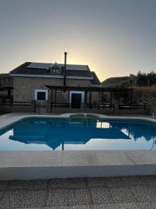a blue swimming pool in front of a house at Tres deseos in Montefrío