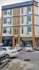 een groot gebouw met auto's geparkeerd op een parkeerplaats bij Residence 21 Boutique Inn in Miri