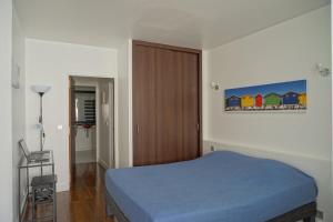 a bedroom with a blue bed and a wooden door at Rue Beaujon - Paris 8 in Paris