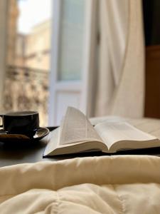 an open book sitting on a table next to a plate at Hotel Akropolis - Museum Hotel in Taranto