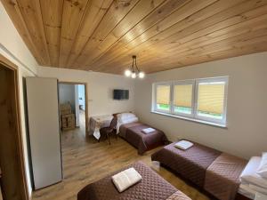 a living room with two beds and a couch at Pensjonat Rzepniki in Rzepniki