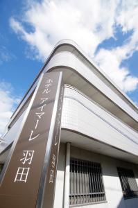 a building with a sign on the side of it at Hotel Imalle Haneda in Kawasaki