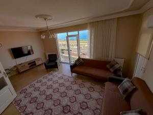a living room with a couch and a large window at MİLA SUİTE in Trabzon