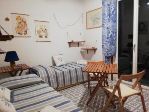 a living room with two beds and a table at La casa del Capitano, l'uomo e il mare ... in Lipari