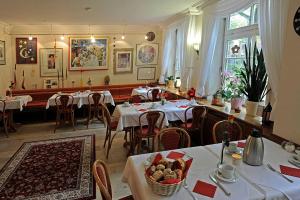 uma sala de jantar com mesas e cadeiras com toalhas de mesa brancas em Hotel St. Georg Garni em Celle