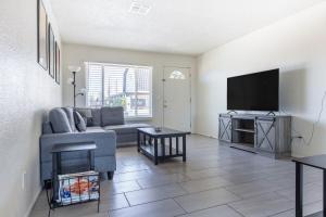 a living room with a couch and a flat screen tv at Cozy 3BR House Near Attractions & Shopping in Phoenix