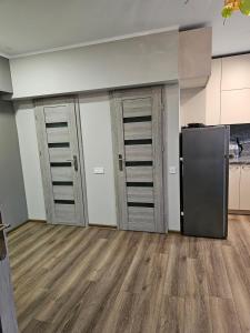 a kitchen with wooden floors and a refrigerator at Koknese City Apartment in Koknese