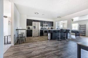 a kitchen with black and white appliances and wooden floors at Cozy 3BR House Near Attractions & Shopping in Phoenix