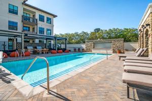 une piscine avec une terrasse et un bâtiment dans l'établissement San Carlos 2BR w Gym Pool BBQ nr Caltrain SFO-910, à San Carlos