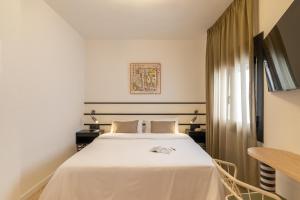 a hotel room with a bed and a table at Hotel Robson - Smart Hotel in Lloret de Mar