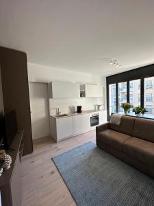 a living room with a couch and a kitchen at Live Lugano - Via A Riva in Lugano