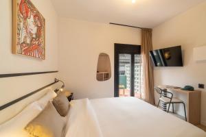 a hotel room with a white bed and a table at Hotel Robson - Smart Hotel in Lloret de Mar