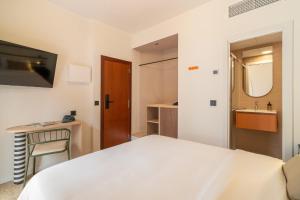 a bedroom with a white bed and a sink at Hotel Robson - Smart Hotel in Lloret de Mar