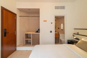a bedroom with a bed and a door to a bathroom at Hotel Robson - Smart Hotel in Lloret de Mar