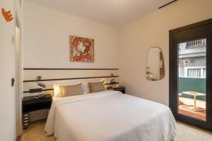 a bedroom with a white bed and a window at Hotel Robson - Smart Hotel in Lloret de Mar