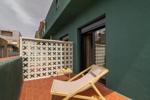 a chair sitting on a patio next to a green wall at Hotel Robson - Smart Hotel in Lloret de Mar