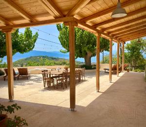 eine hölzerne Pergola mit Tischen und Stühlen auf einer Terrasse in der Unterkunft Lichada Villas in Likhás