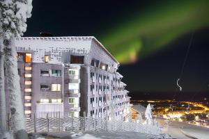 an apartment building with a green light in the sky at Hotel Levi Panorama in Levi