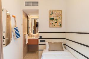 a small bathroom with a bed and a sink at Hotel Robson - Smart Hotel in Lloret de Mar +37 photos