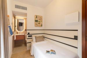 a bedroom with a white bed and a bathroom at Hotel Robson - Smart Hotel in Lloret de Mar