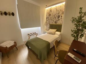 una pequeña habitación con una cama y una mesa en Apartamentos Peñalara, en Segovia