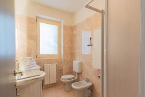 a bathroom with a white toilet and a sink at Casa Vela by Rent All Como in Sala Comacina +40 photos