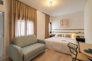 a hotel room with a bed and a chair at Hotel Robson - Smart Hotel in Lloret de Mar