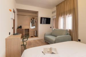 a hotel room with a bed and a chair at Hotel Robson - Smart Hotel in Lloret de Mar