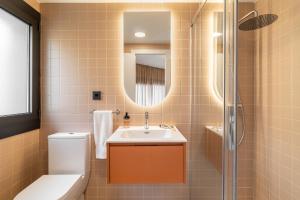 a bathroom with a sink and a toilet and a mirror at Hotel Robson - Smart Hotel in Lloret de Mar