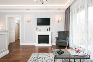 a living room with a chair and a television at Executive 2-bedroom Apartment in Krakow
