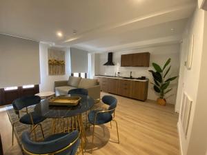 a living room with a table and chairs and a kitchen at Apartamentos Peñalara in Segovia