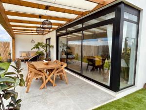 eine Terrasse mit einem Holztisch und Glastüren in der Unterkunft Bungalow + Piscina independiente in La Oliva