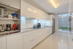 a white kitchen with white cabinets and a window at Villa Casablanca by Welcome Tenerife in Chayofa