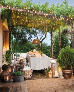 a table under a pergola with lights on it at ALBERGUE RUTA RIo BOROSA in Coto Rios