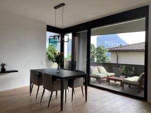 a dining room with a black table and chairs at Live Lugano - Via Massagno in Lugano