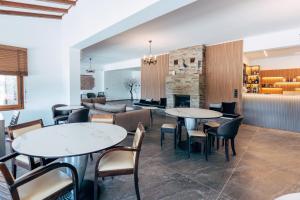 a restaurant with tables and chairs and a fireplace at Hotel Agistro in Angistron