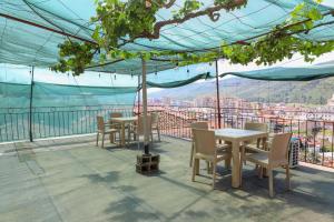 a patio with tables and chairs and a view of a city at Stergjo Townview Residences in Berat