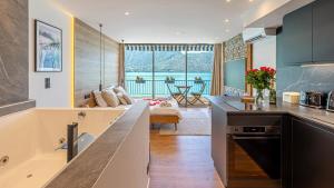 a kitchen with a counter and a living room at Le Reflet du Lac in Tresserves