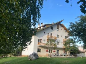 a large white building with balconies and a yard at Mont Crai in Zărneşti