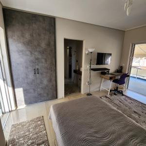 a bedroom with a bed and a desk and a sliding glass door at Elite Port in Piraeus