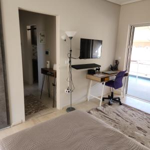 a bedroom with a bed and a desk with a computer at Elite Port in Piraeus