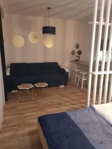 a living room with a black couch and a table at Apartament Północna in Darłowo