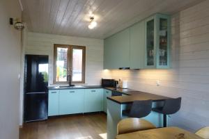 una cucina con armadi blu, lavandino e tavolo di Sielski Domek Ręboszewo 94 a Ręboszewo