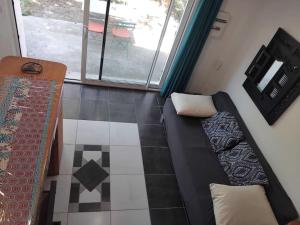 a room with a couch and a floor with a window at Petit Nid in Bagard