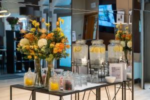 a table with vases of flowers and glass jars at Abba Rambla Hotel in Barcelona