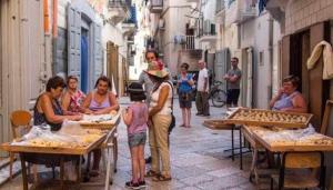a group of people standing around in an alley at Stanza matrimoniale bagno privato in Mola di Bari +2 photos