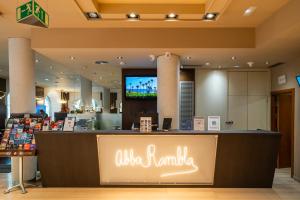 a store with a counter with a tv above it at Abba Rambla Hotel in Barcelona