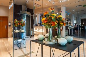 a table with vases of flowers on it in a store at Abba Rambla Hotel in Barcelona +37 photos