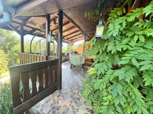 Un porche cubierto con un banco y plantas. en Cozy Quiet Retreat 70km from Sofia, en Kyustendil