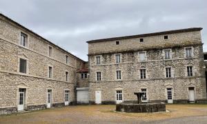 Les Asphodeles chambre familiale Lilah في سانت هيبوليت - دو - فورت: مبنى كبير من الطوب وامامه تمثال